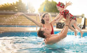 Family with infant playing in pool