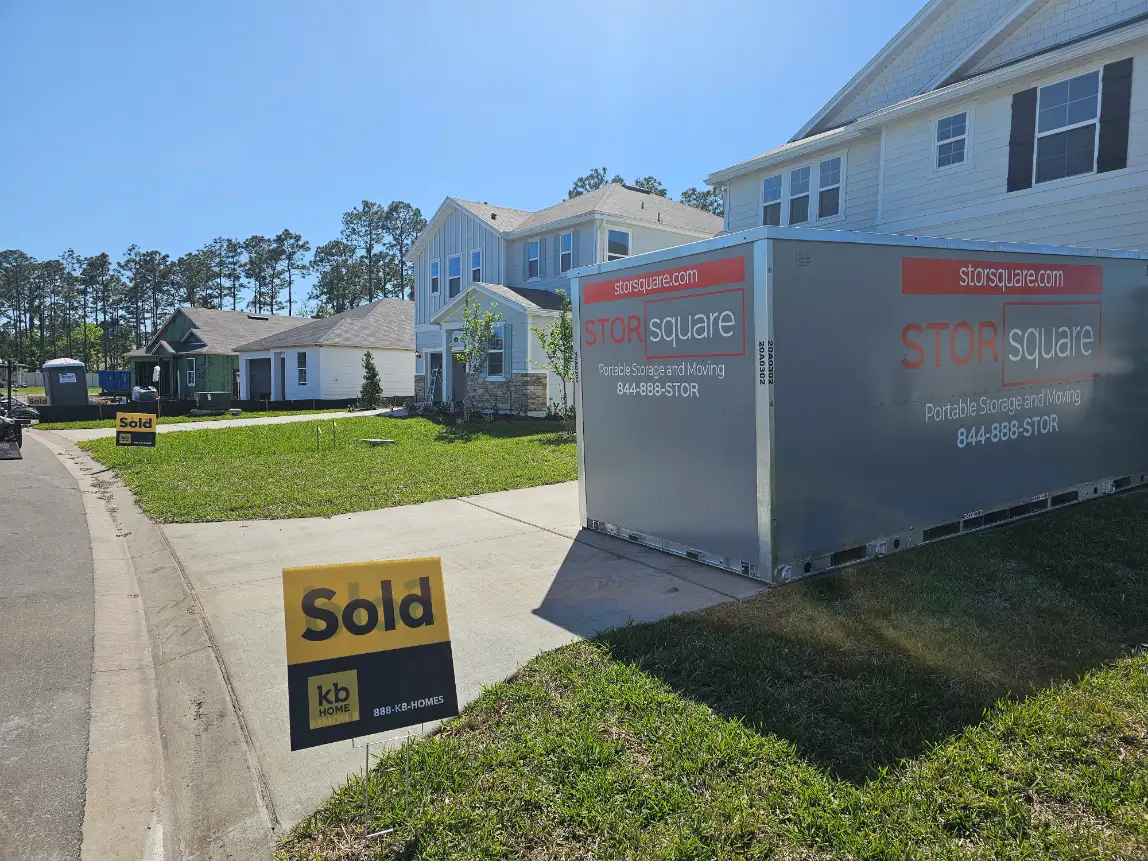 STORsquare portable storage container beside a sold home in a residential neighborhood.