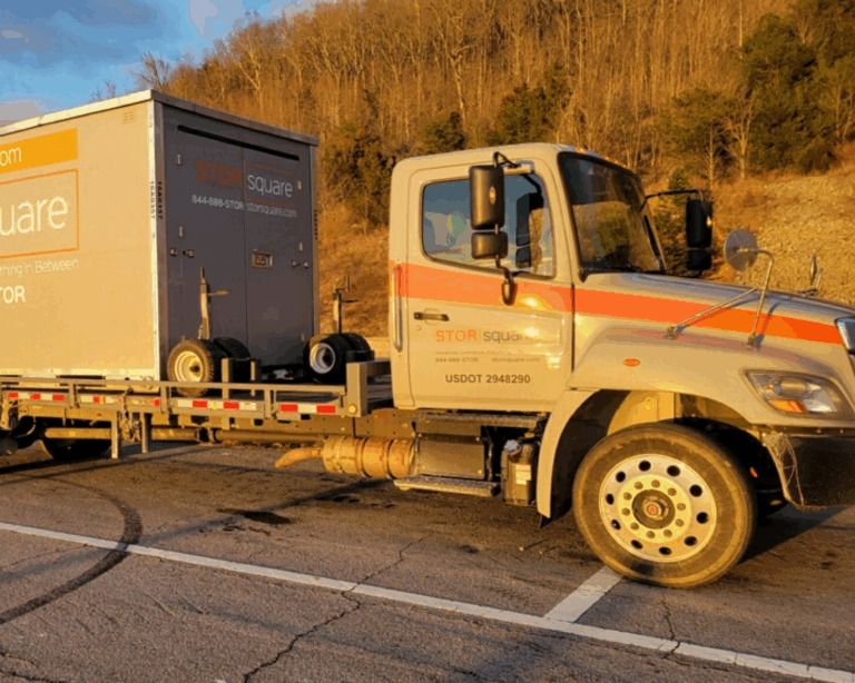 A STORsquare truck carrying a storage container rental in Calhoun at sunset