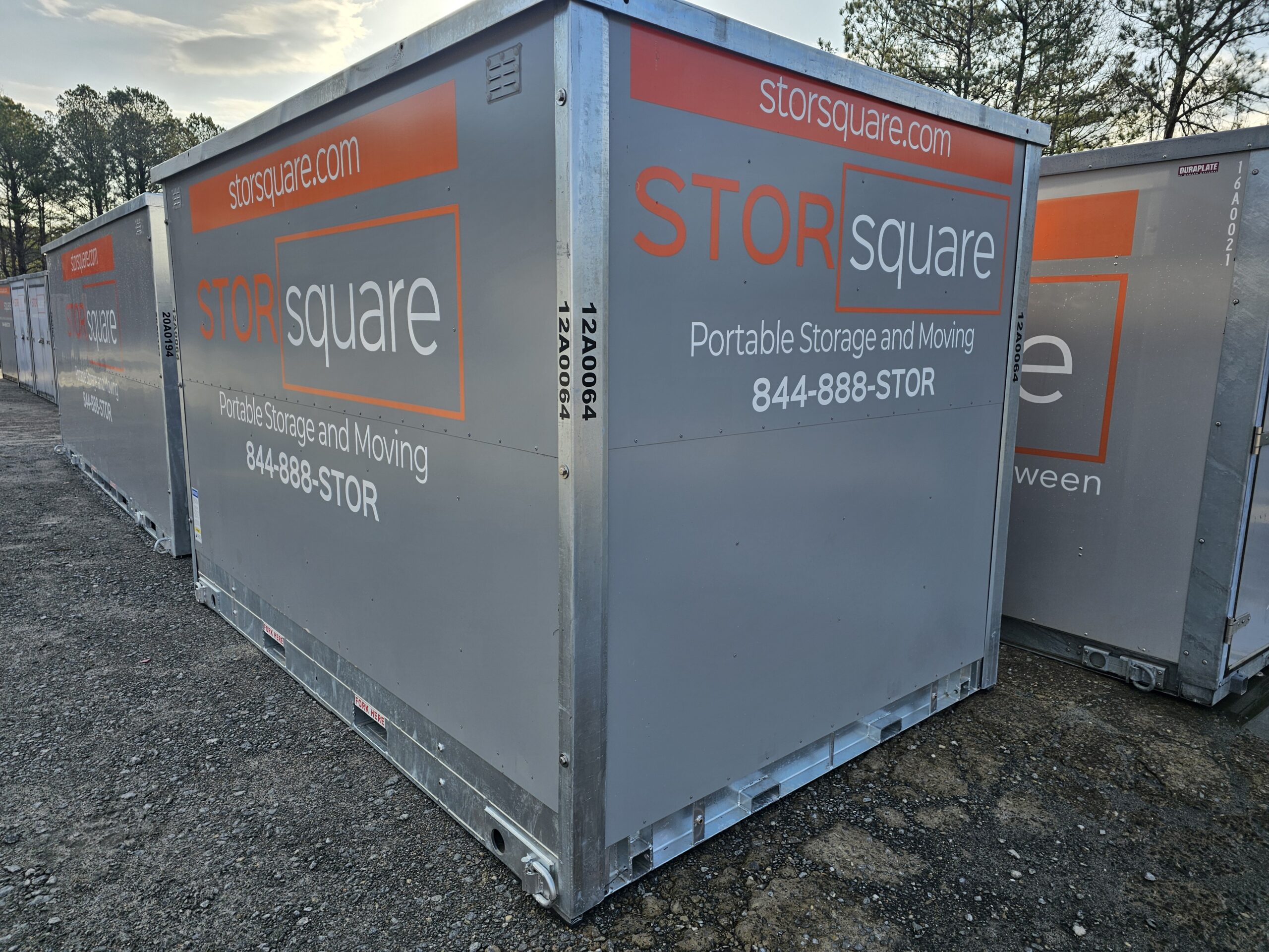 On-site storage containers for roofing materials and equipment lined up on a job site, providing secure, weather-protected storage during active roofing projects.
