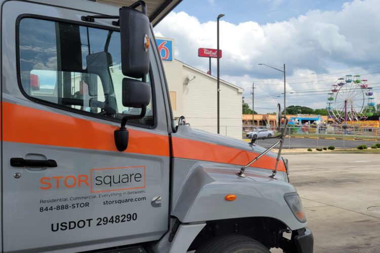 STORsquare truck delivering onsite storage containers to support secure material and tool storage at an active construction site.