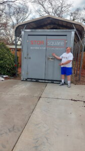 A homeowner standing beside a mobile storage unit in Decatur, Georgia, showing how portable storage solves surprises during unexpected home changes.