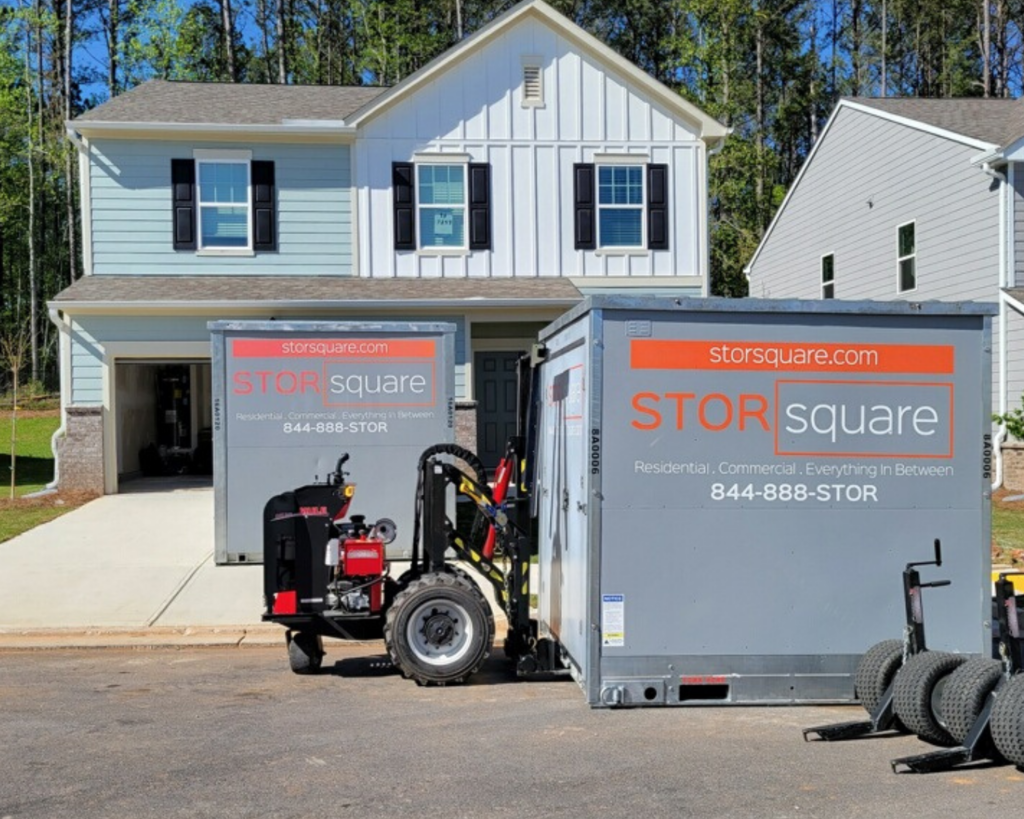 A STORsquare portable storage container being delivered on a wide, open driveway, showing a setup that doesn’t require precision placement or complex coordination.