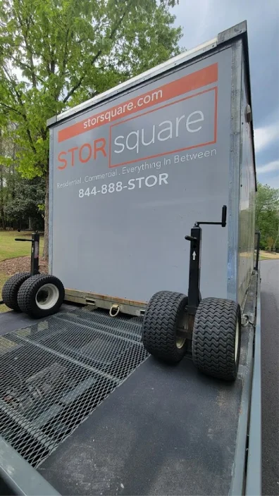 STORsquare long distance moving container secured on a flatbed during portable storage transport across Central Florida.