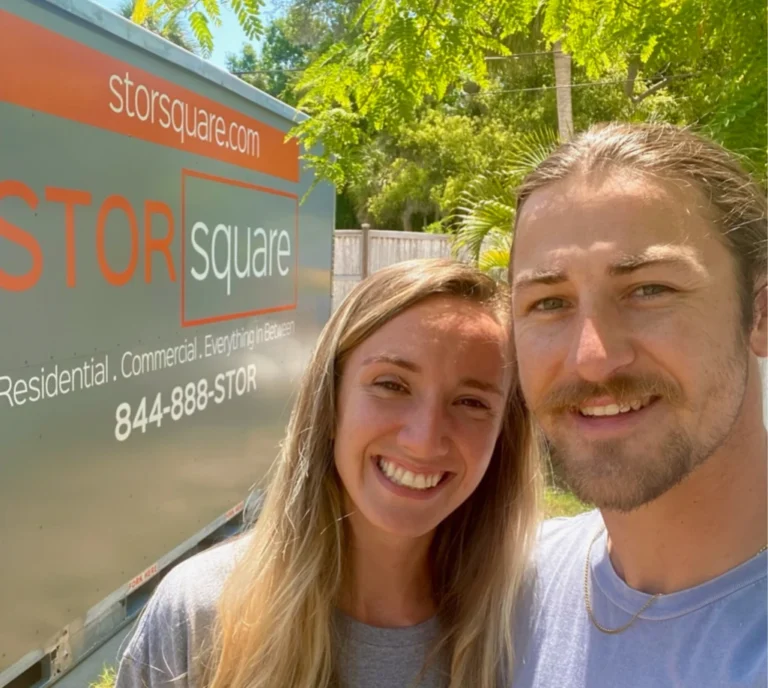Happy customers standing beside a STORsquare moving container during a residential move.