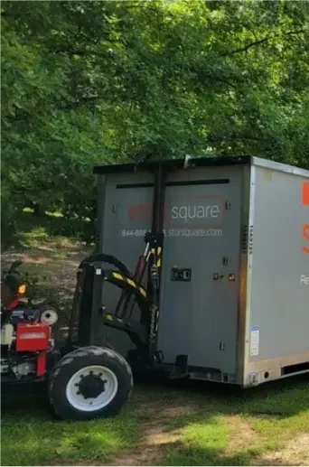 STORsquare long distance moving containers placed along a rural driveway in the Southeast, supporting flexible interstate moving with portable storage.