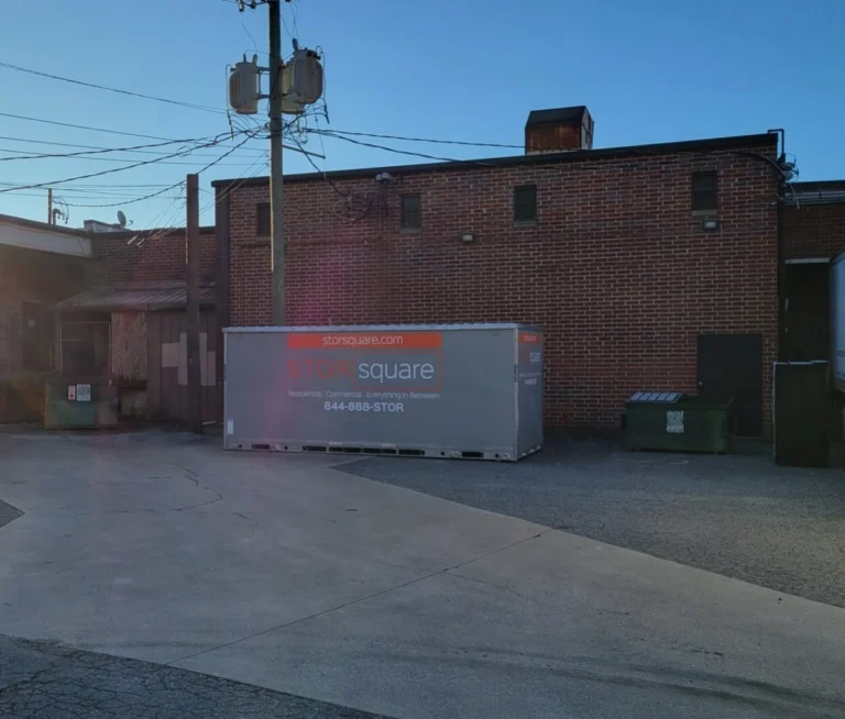 STORsquare commercial storage container placed in a rear loading area behind a brick commercial building.