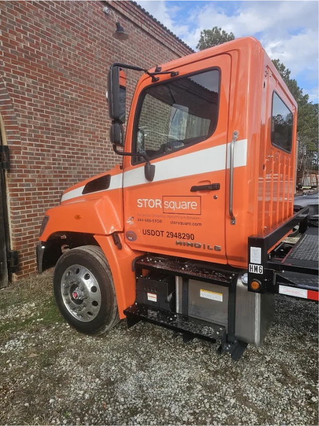 STORsquare flatbed delivery truck used for portable storage container delivery at a residential site in Knoxville, Tennessee.