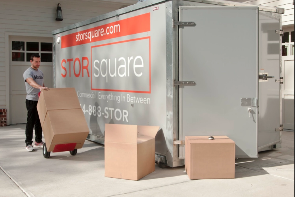 A customer loading boxes into a STORsquare portable storage container, representing flexible local and long-distance delivery options across Georgia.