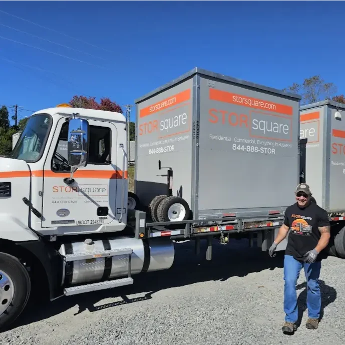 STORsquare driver hauling sealed portable storage containers on a flatbed truck during an interstate move in the Knoxville area.
