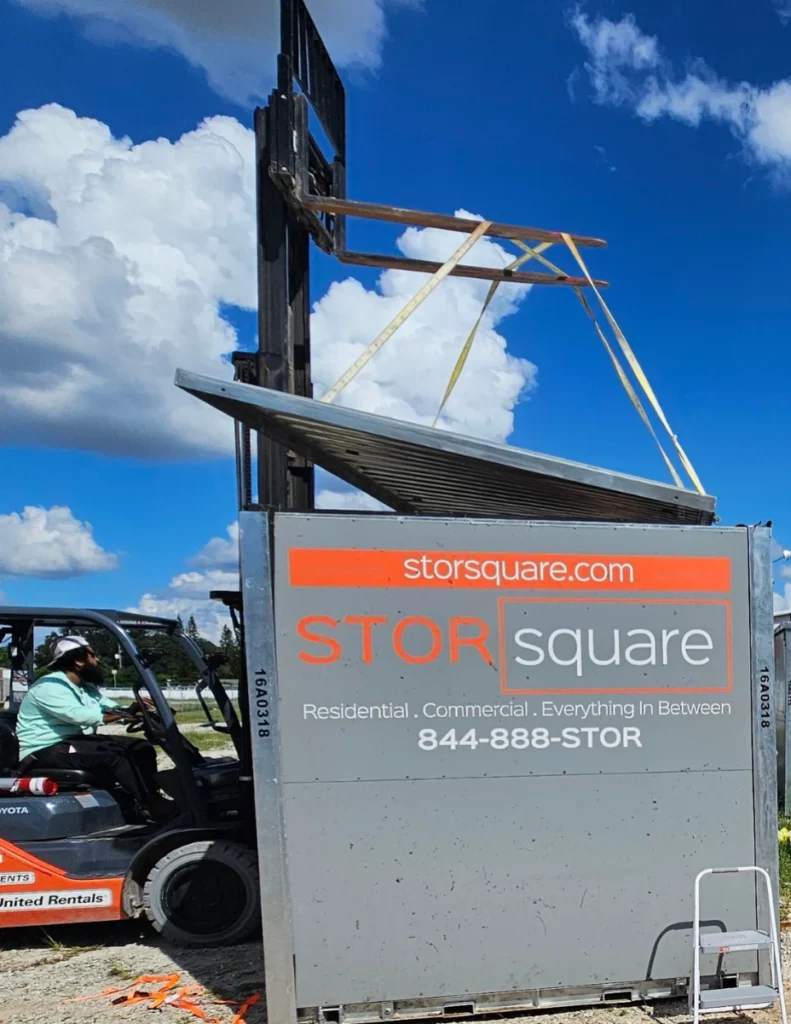 A STORsquare container is loaded using equipment, supporting long distance moving with storage during secure on-site handling.