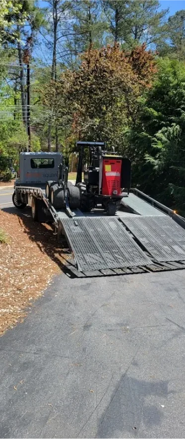 STORsquare portable storage container loaded onto a transport trailer on a wooded residential driveway in Tennessee.