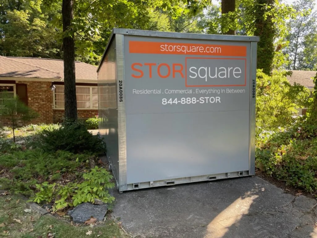 A STORsquare container sits securely in a residential driveway, showing portable storage for interstate moves with convenient on-site access.