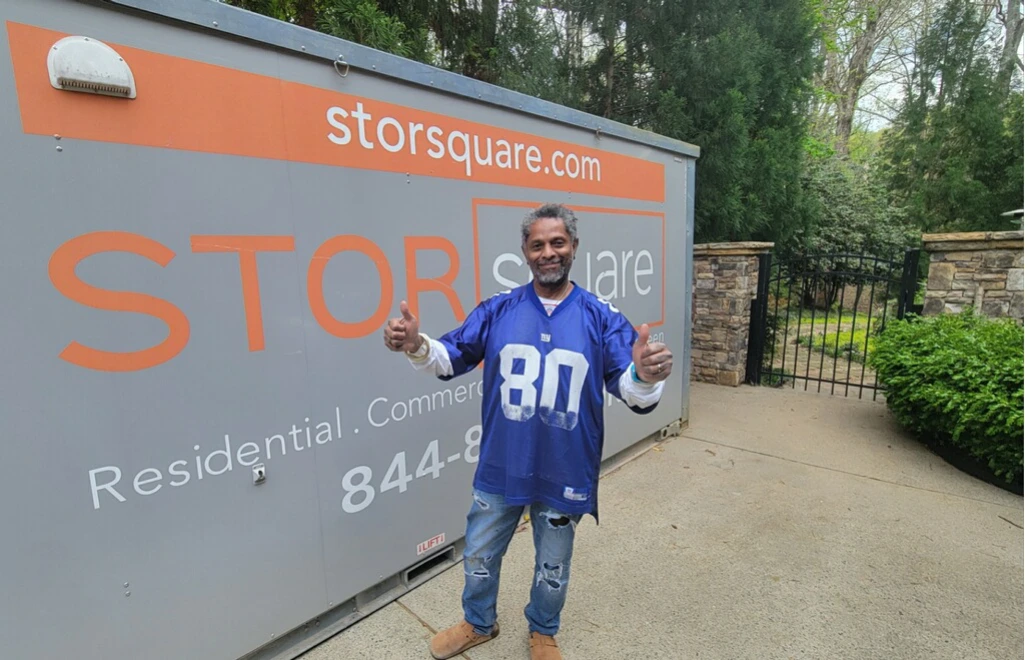 Happy customer standing beside a portable storage container in Decatur, showing how portable storage solves surprises during major life changes.