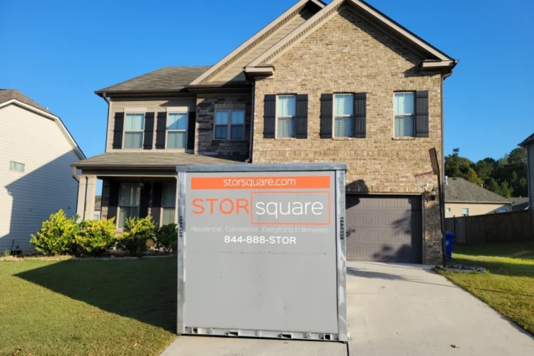 Mobile storage unit placed in front of a two-story home during a moving transition.