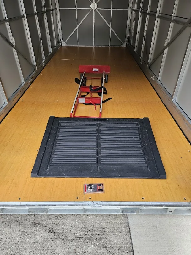 Interior view of a STORsquare portable storage container showing a loading ramp and moving dolly setup in Charlotte, NC.