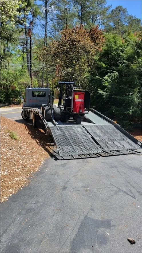 STORsquare portable storage container being loaded onto a flatbed trailer using equipment on a residential street in Charlotte, NC.