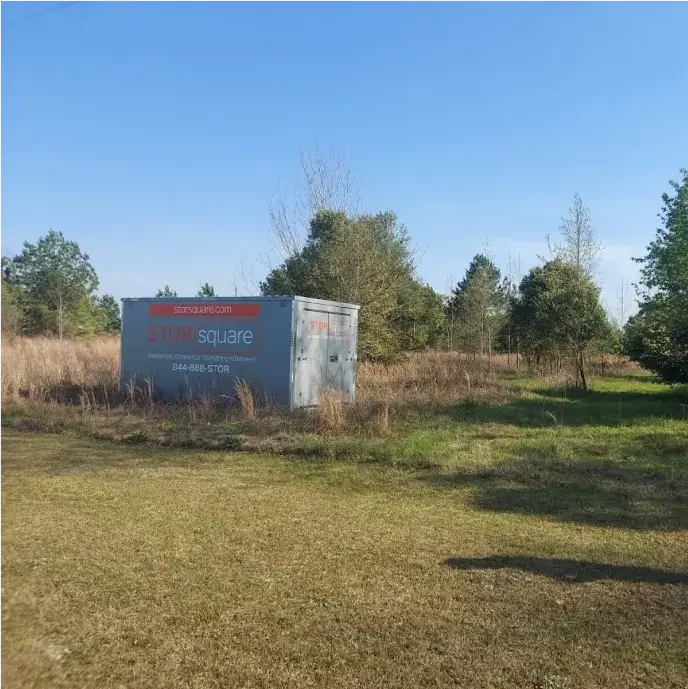 STORsquare portable storage container placed in a grassy open area in Cornelius with trees and field visible.