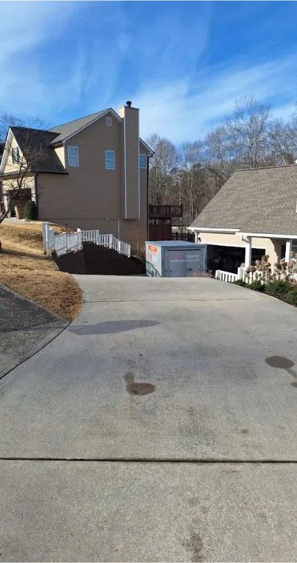 STORsquare storage container placed at the base of a long, sloped residential driveway between two homes in a South Carolina neighborhood.