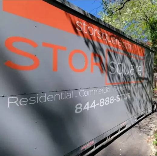 STORsquare storage container positioned along a narrow paved path beside trees and landscaping at a residential property in North Carolina.
