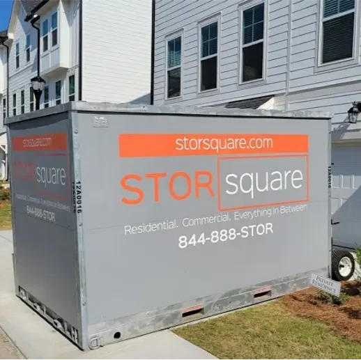 STORsquare storage container placed beside a row of townhomes along a sidewalk in a North Carolina residential community.