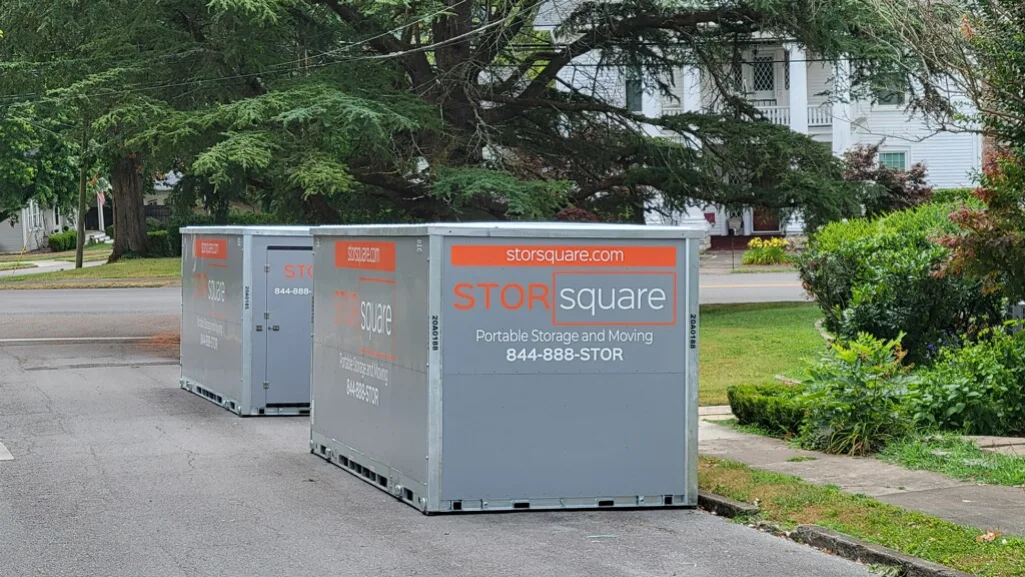 Portable storage containers parked on a neighborhood street while organizing boxes with the perfect moving day playlist playing in the background.