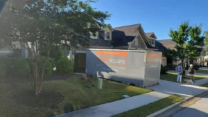 Portable storage container in a driveway helping reduce clutter so drivers can stay alert on long drives during a move