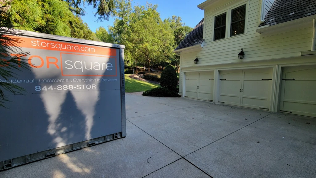 Portable storage container in a driveway helping reduce clutter so drivers can stay alert on long drives during a move