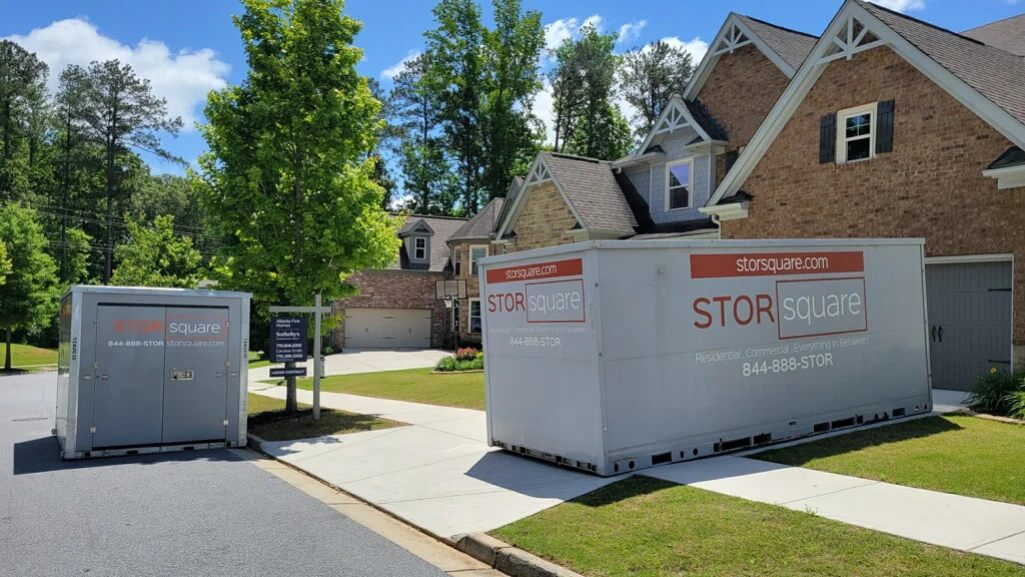 Two portable storage containers placed in a driveway during a home move