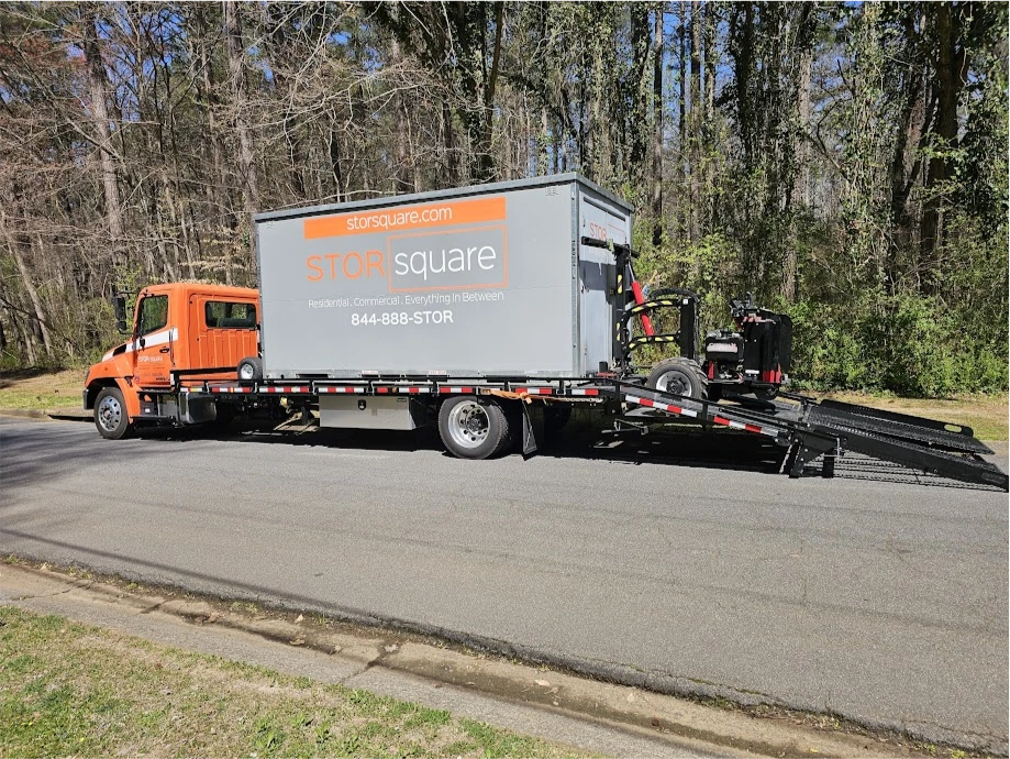 STORsquare delivery truck unloading a portable storage container on a residential street in Knoxville, TN.
