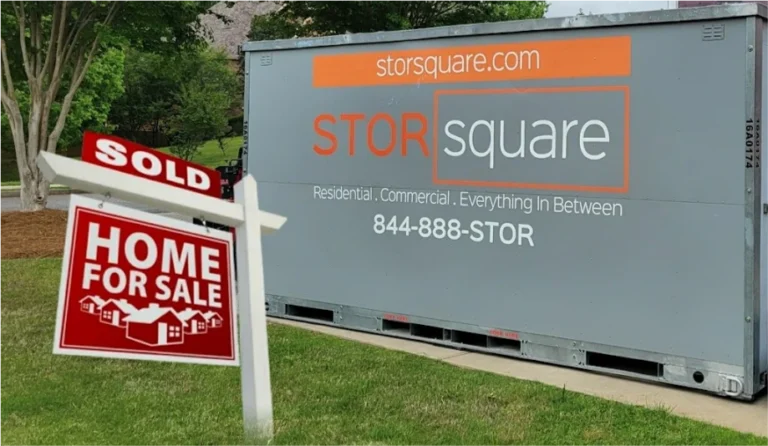 STORsquare portable storage container beside a sold home sign in Lakeland, FL, representing moving and home staging support.