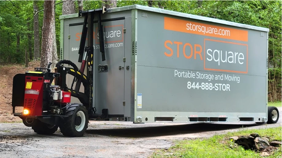 STORsquare mobile storage unit being positioned on a driveway in Knoxville, TN with delivery equipment attached.