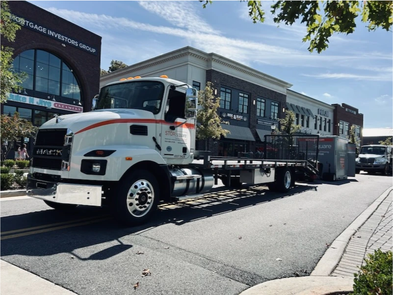 STORsquare delivery truck transporting a portable storage container through a commercial street in Lakeland, FL.