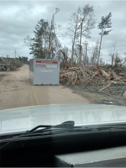 STORsquare portable storage container placed along a rural Mooresville NC road near cleared trees and debris.