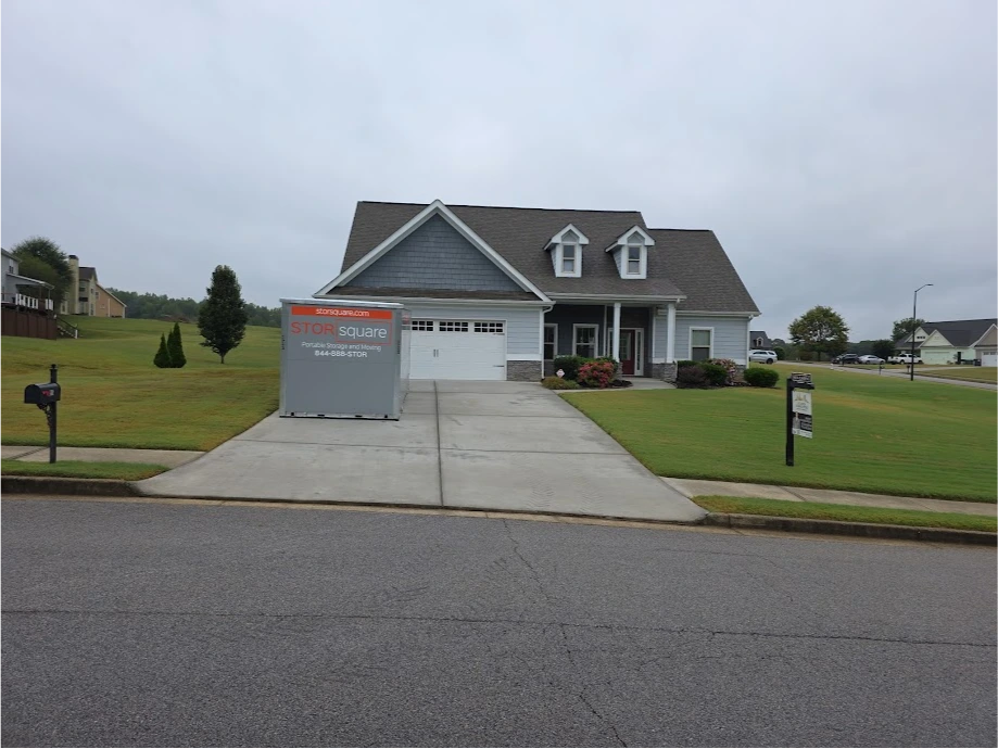 STORsquare storage container placed in a Huntersville NC driveway in front of a single-family home on a rainy day.
