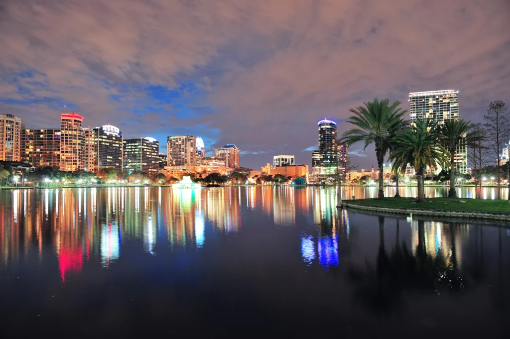 Orlando downtown skyline over Lake Eola at dusk with urban skyscrapers and lights.