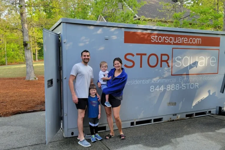 Family standing beside a STORsquare container for portable storage units moving during a long-distance relocation