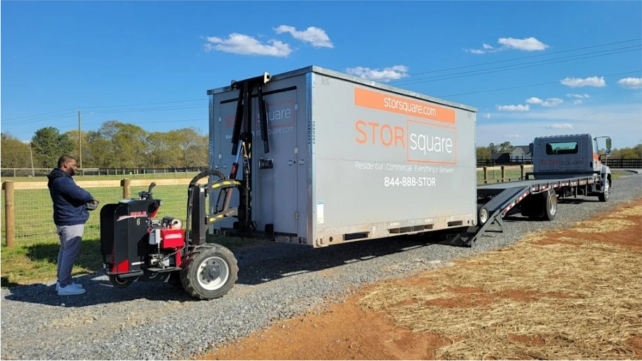 STORsquare mobile storage units being positioned in Salisbury NC using delivery equipment on a gravel surface