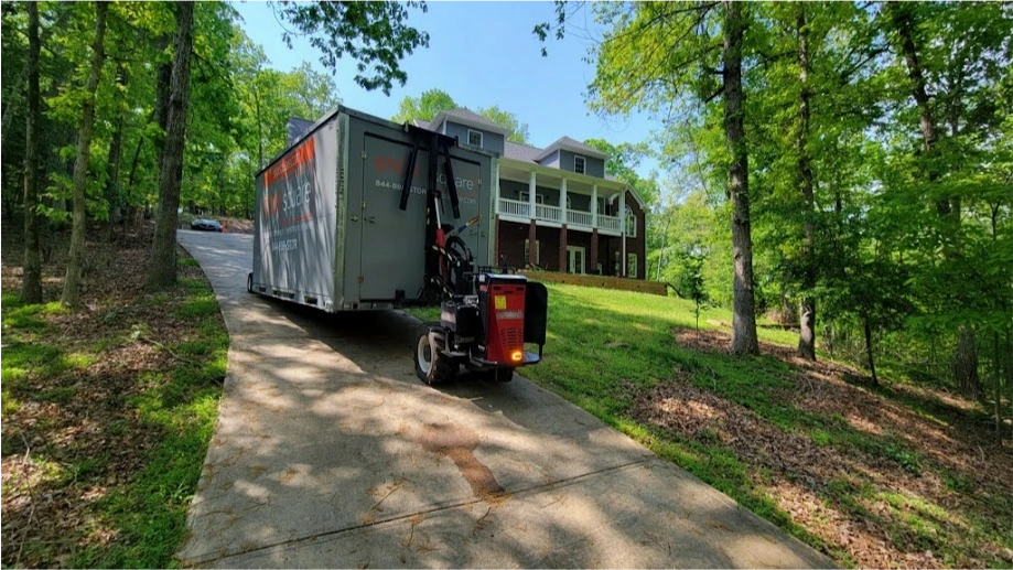 STORsquare mobile storage units being positioned on a steep High Point driveway near a wooded residential property