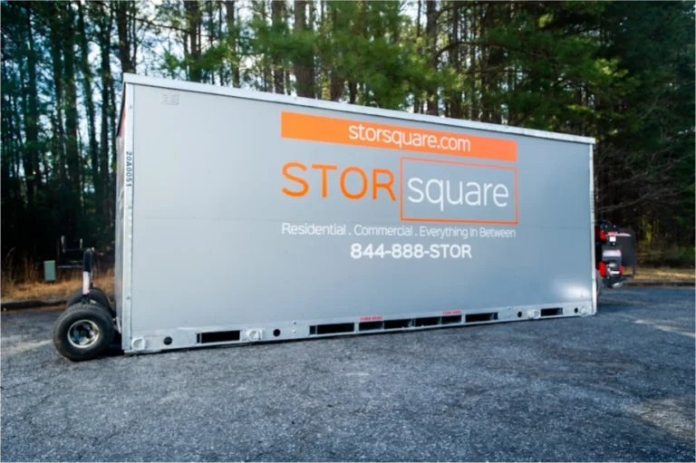 STORsquare moving container placed on a gravel surface in Duluth, GA with surrounding trees and delivery equipment visible