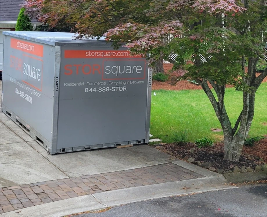 STORsquare portable storage units placed on a residential driveway in Duluth, GA next to landscaping and a tree