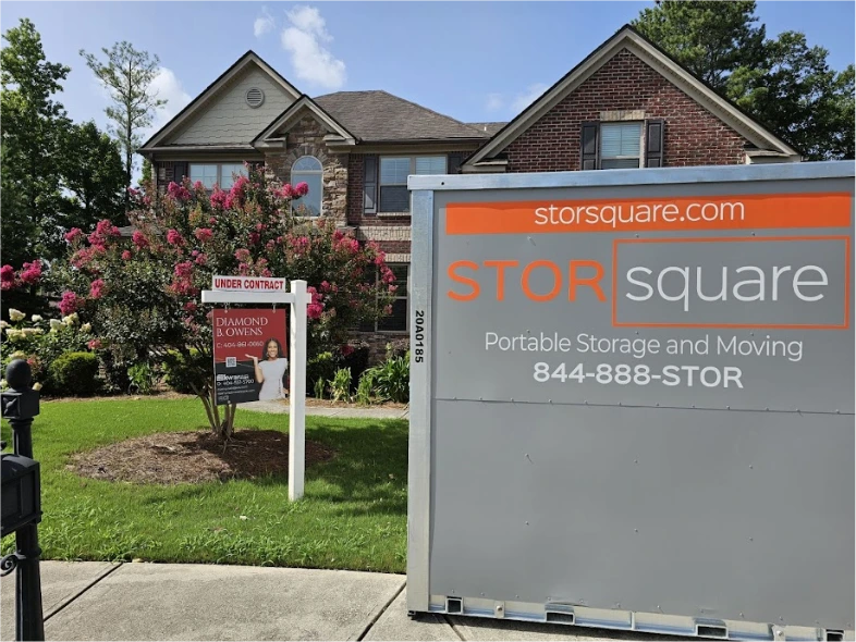 STORsquare portable storage units placed at a Decatur home with a real estate sign during staging or moving