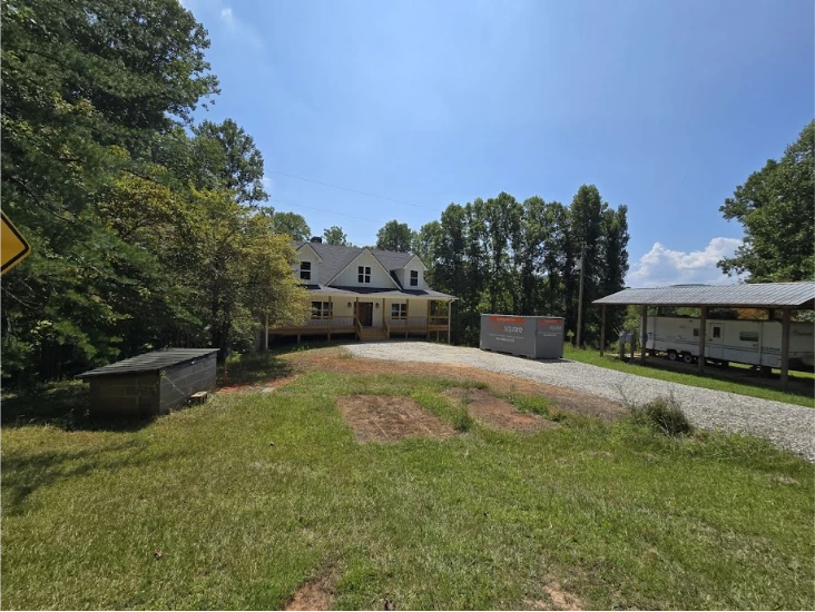 STORsquare portable storage units placed on a Maryville rural property beside a home, gravel drive, and covered parking