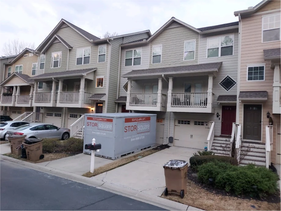 STORsquare portable storage units placed in a townhome driveway in Davenport, FL with parked cars and residential buildings visible.