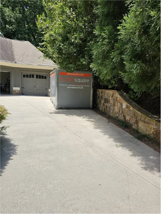 STORsquare storage container placed on a residential driveway in Smyrna, GA beside a retaining wall and garage