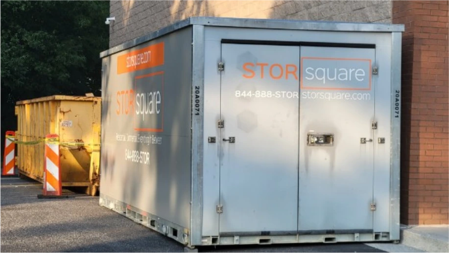 STORsquare storage container rentals positioned beside a commercial building in Davenport, FL near construction equipment.
