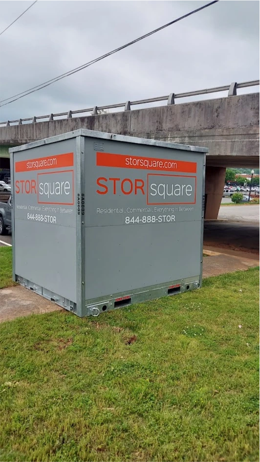 STORsquare storage container rentals placed on a grassy roadside in Buford near an overpass and traffic area