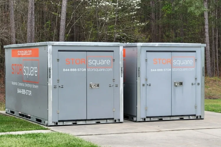 Two portable storage containers used as temporary storage solutions during a larger garage floor coating or remodeling project