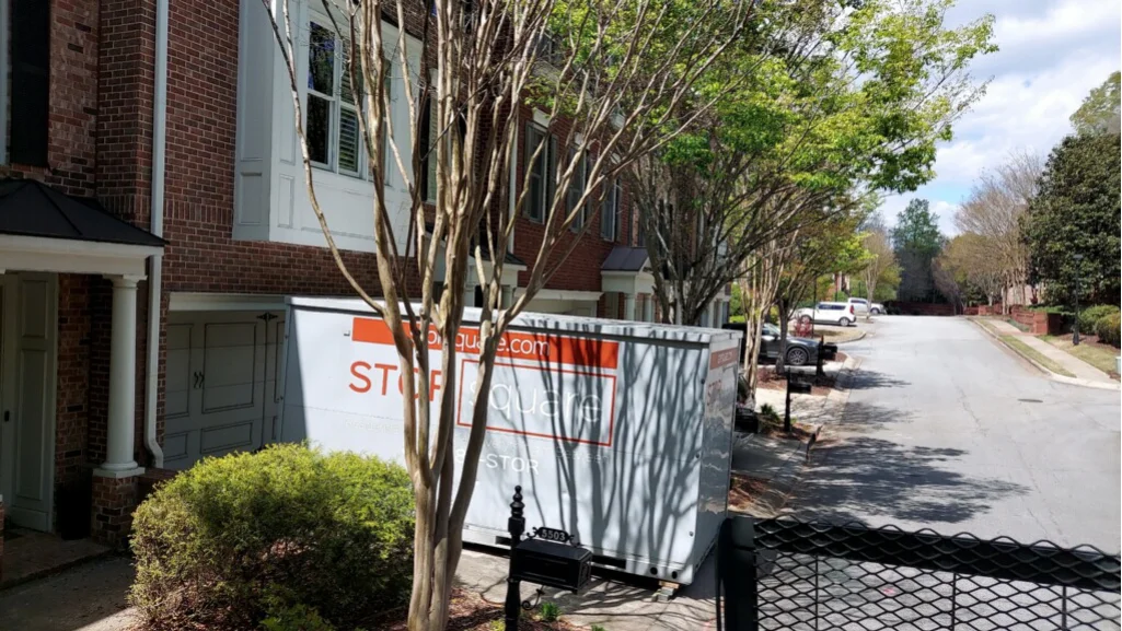 Temporary storage solutions with a portable container placed outside a townhome during a garage floor coating project
