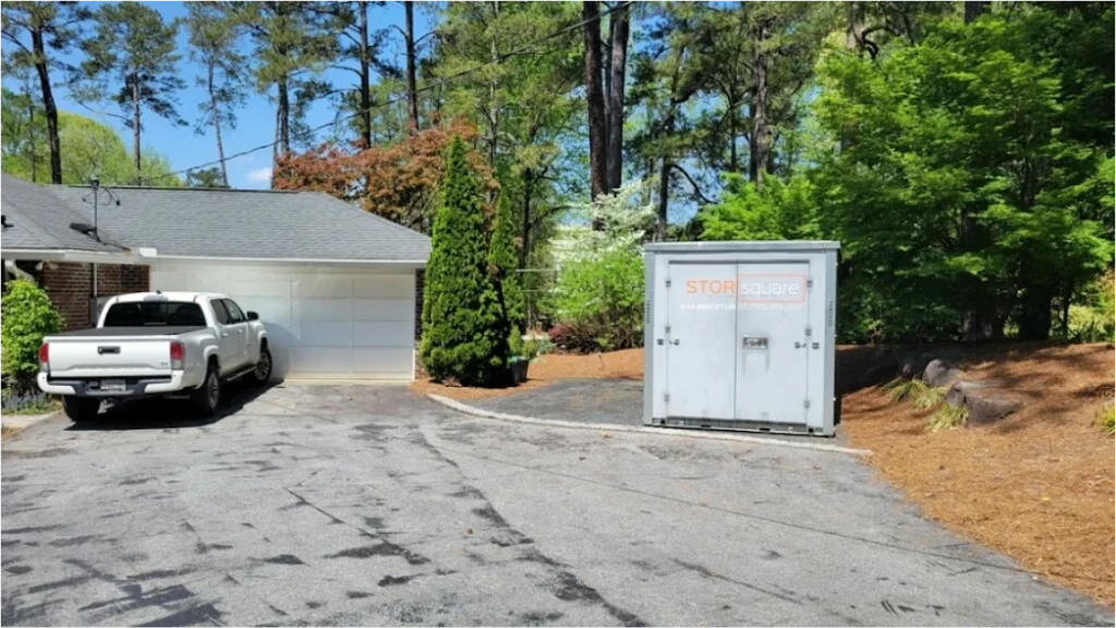 STORsquare moving container set on a wide Bellaire driveway near a parked pickup and wooded yard.